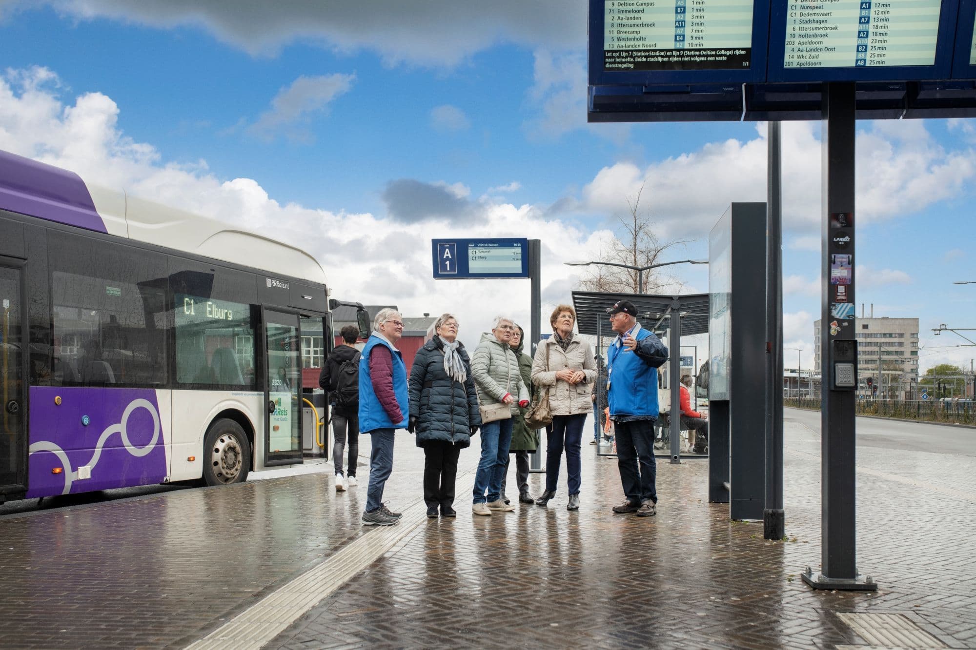 Reizigers bij een busstation