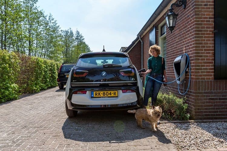 Vrouw laadt auto elektrisch op