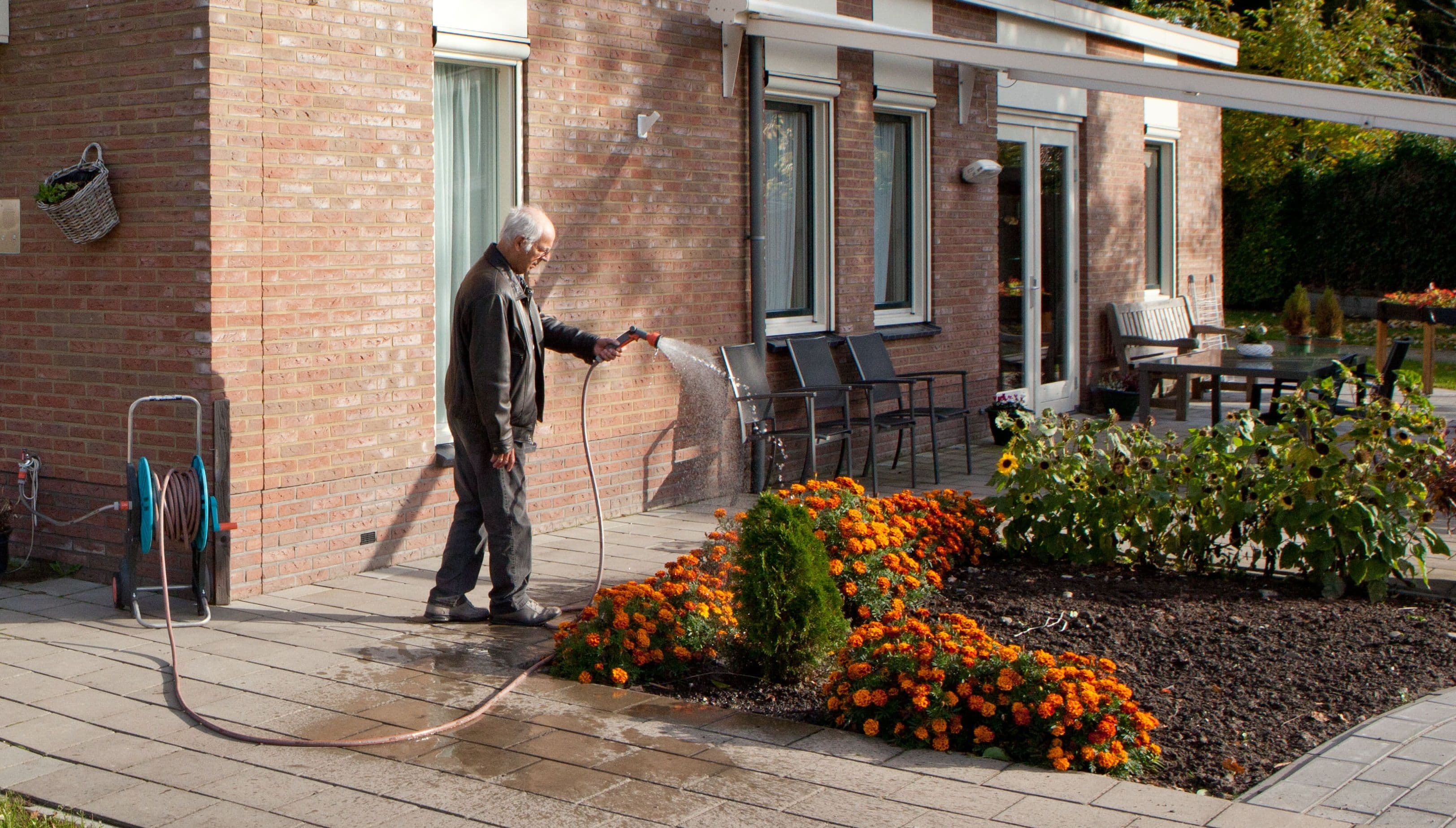 meneer is de tuin aan het sproeien